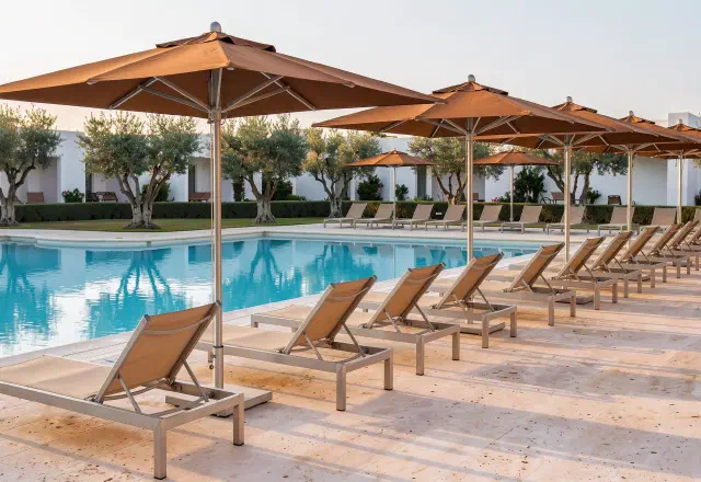 Lounge chairs and umbrellas along a resort pool terrace
